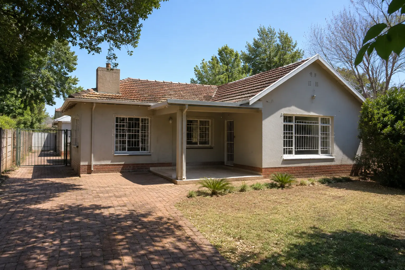 Modest freestanding house with a paved driveway in a South African suburb