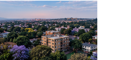 Aerial view over a leafy Gauteng suburb of multi-storey apartment buildings among jacaranda trees